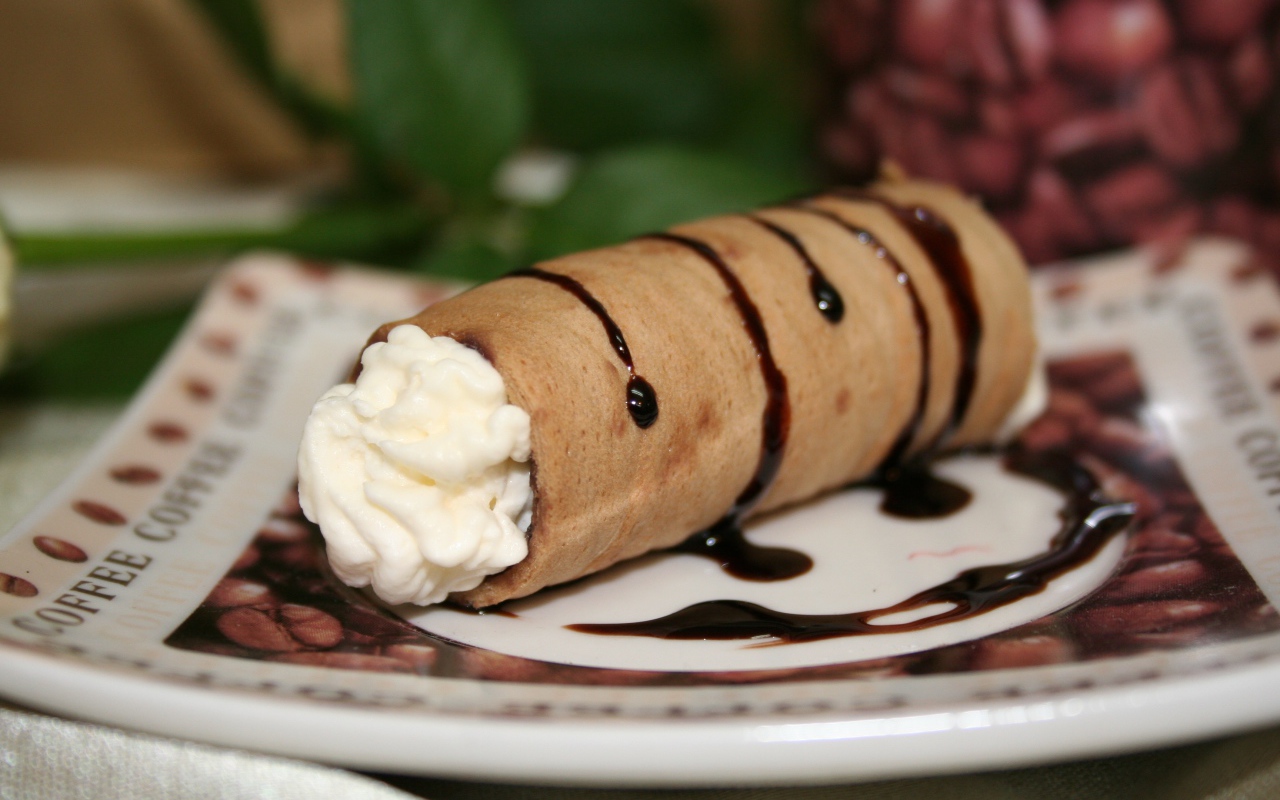 Сладкая трубочка с ванильным кремом на тарелке