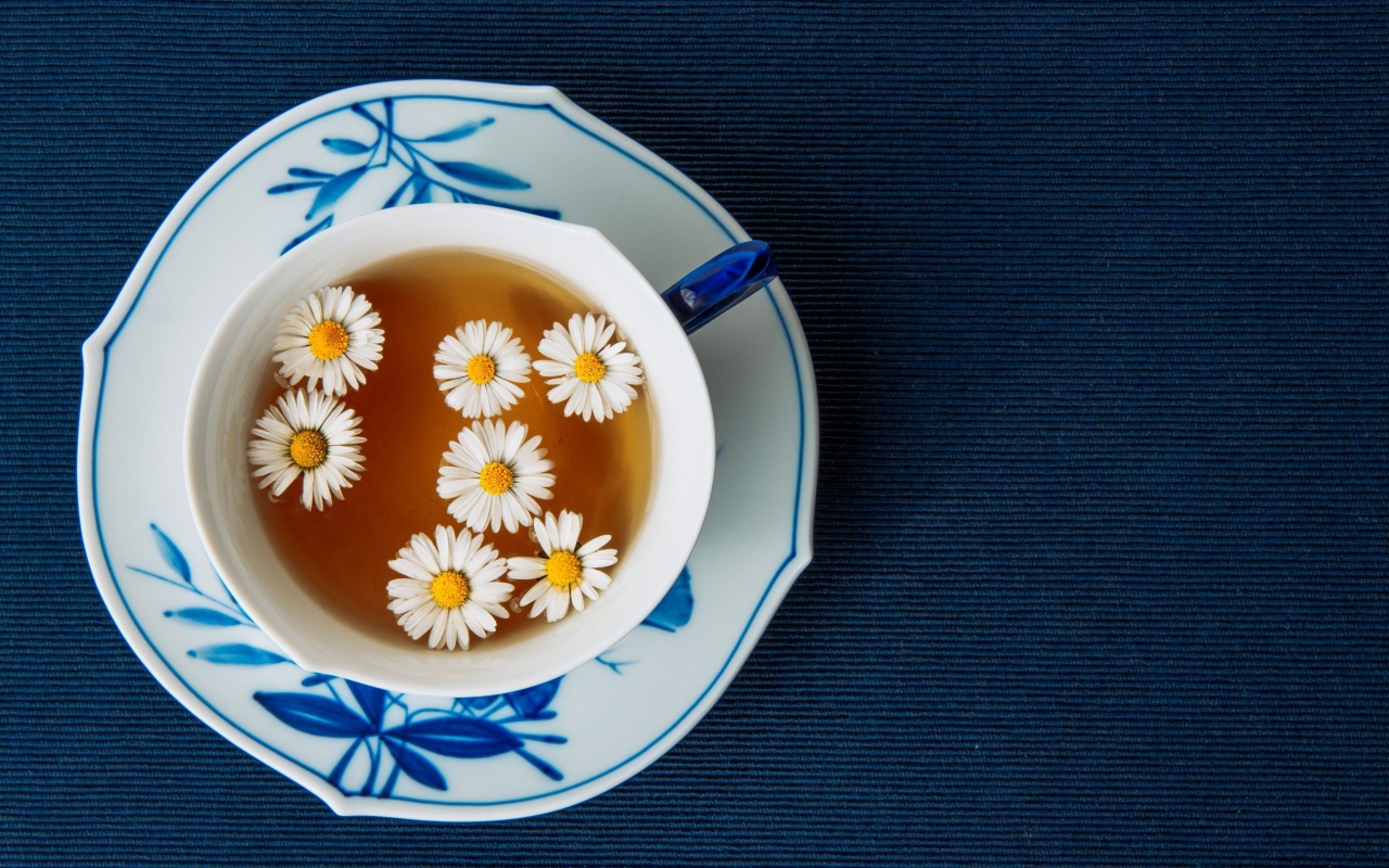 Чашка горячего чая с ромашкой на столе