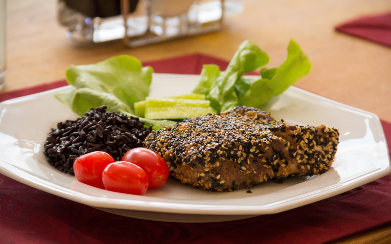 Кусок мяса на тарелке с рисом и овощами 