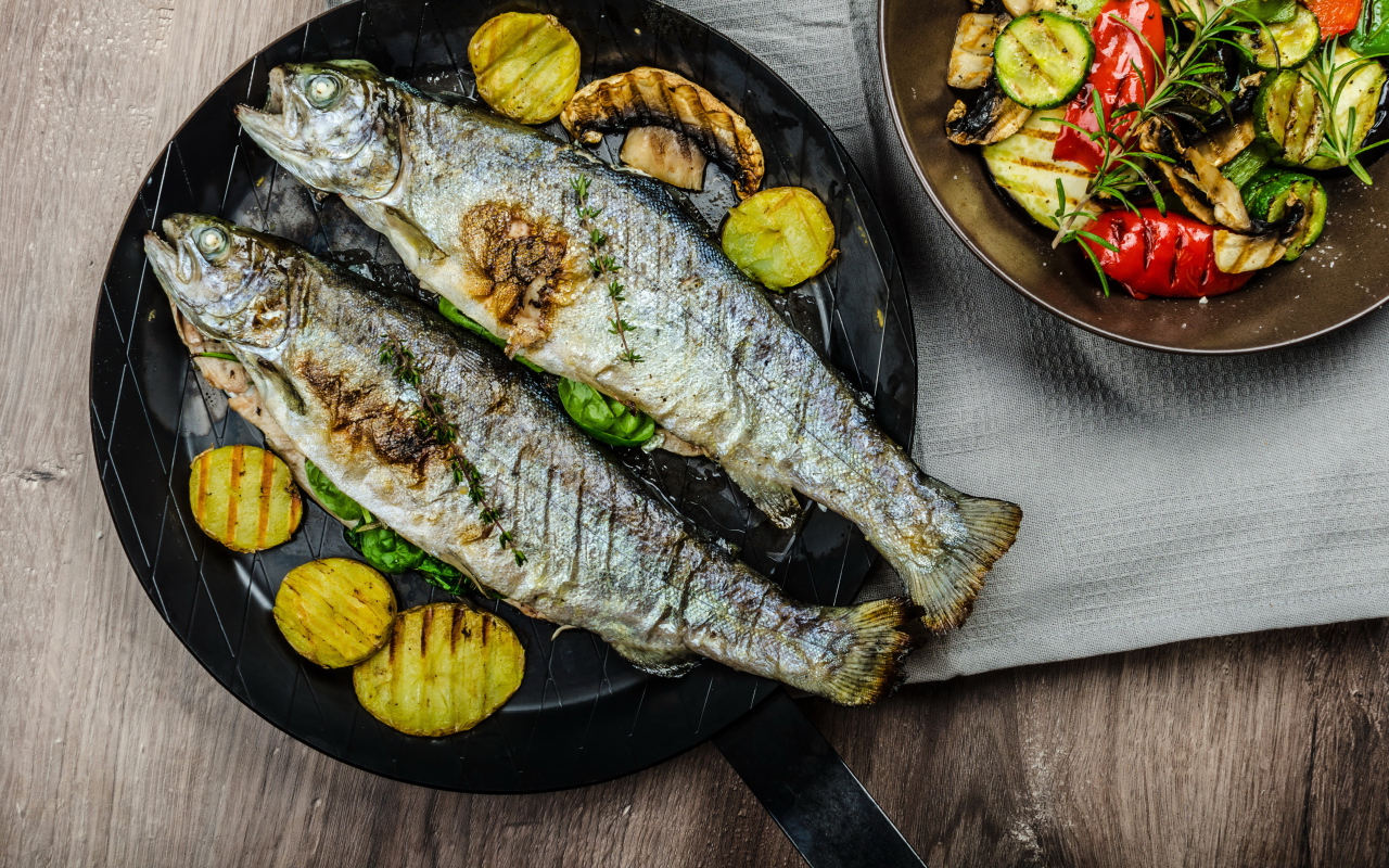 Две рыбины на сковороде с овощами