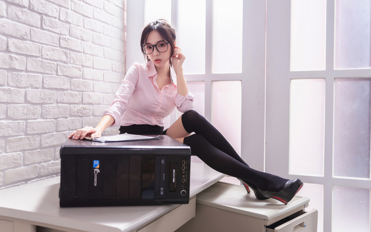 Девушка азиатка в черных чулках с системным блоком