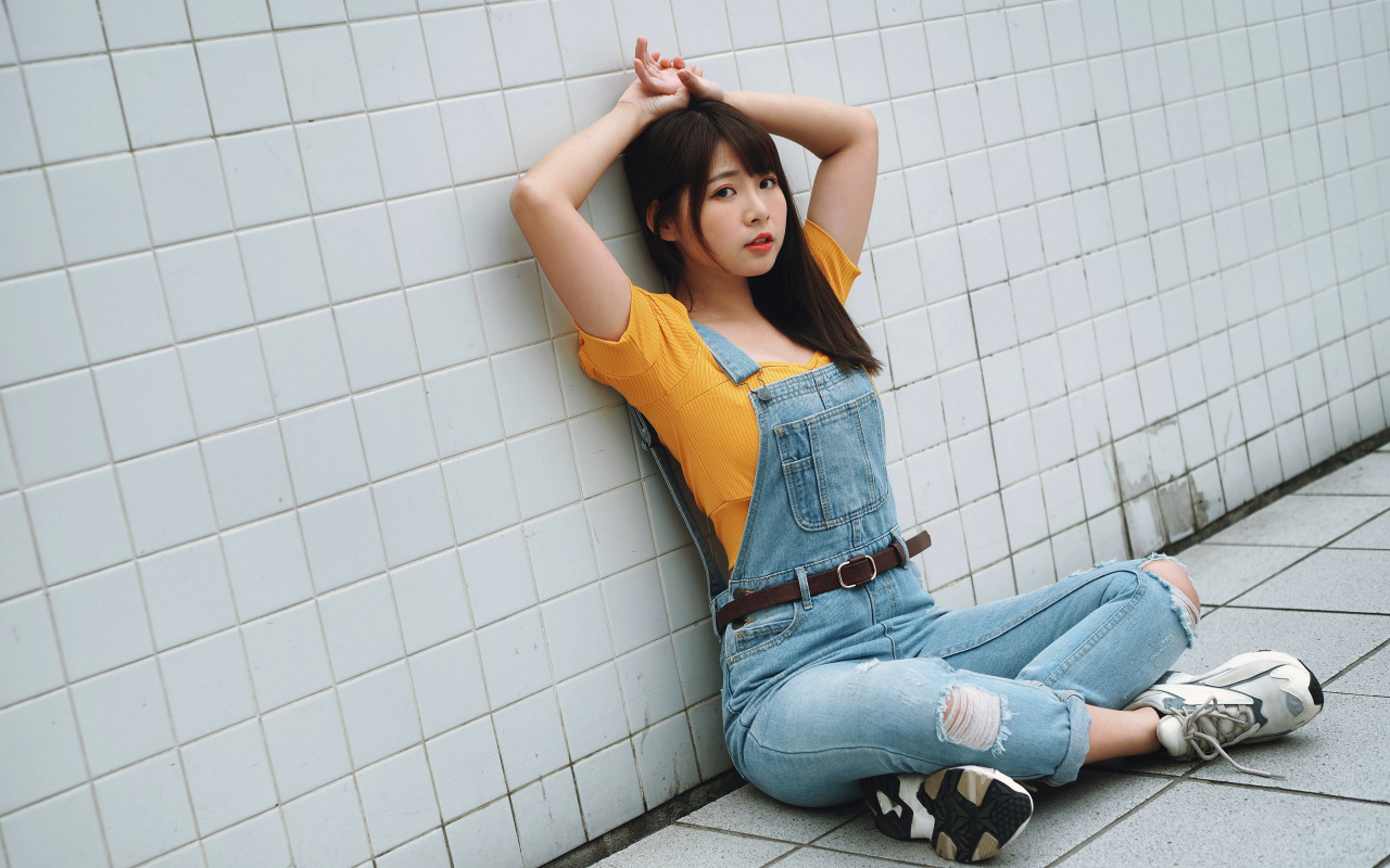 Девушка азиатка в джинсовом комбинезоне 