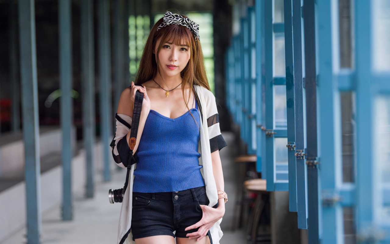 Девушка азиатка с фотоаппаратом в руках 