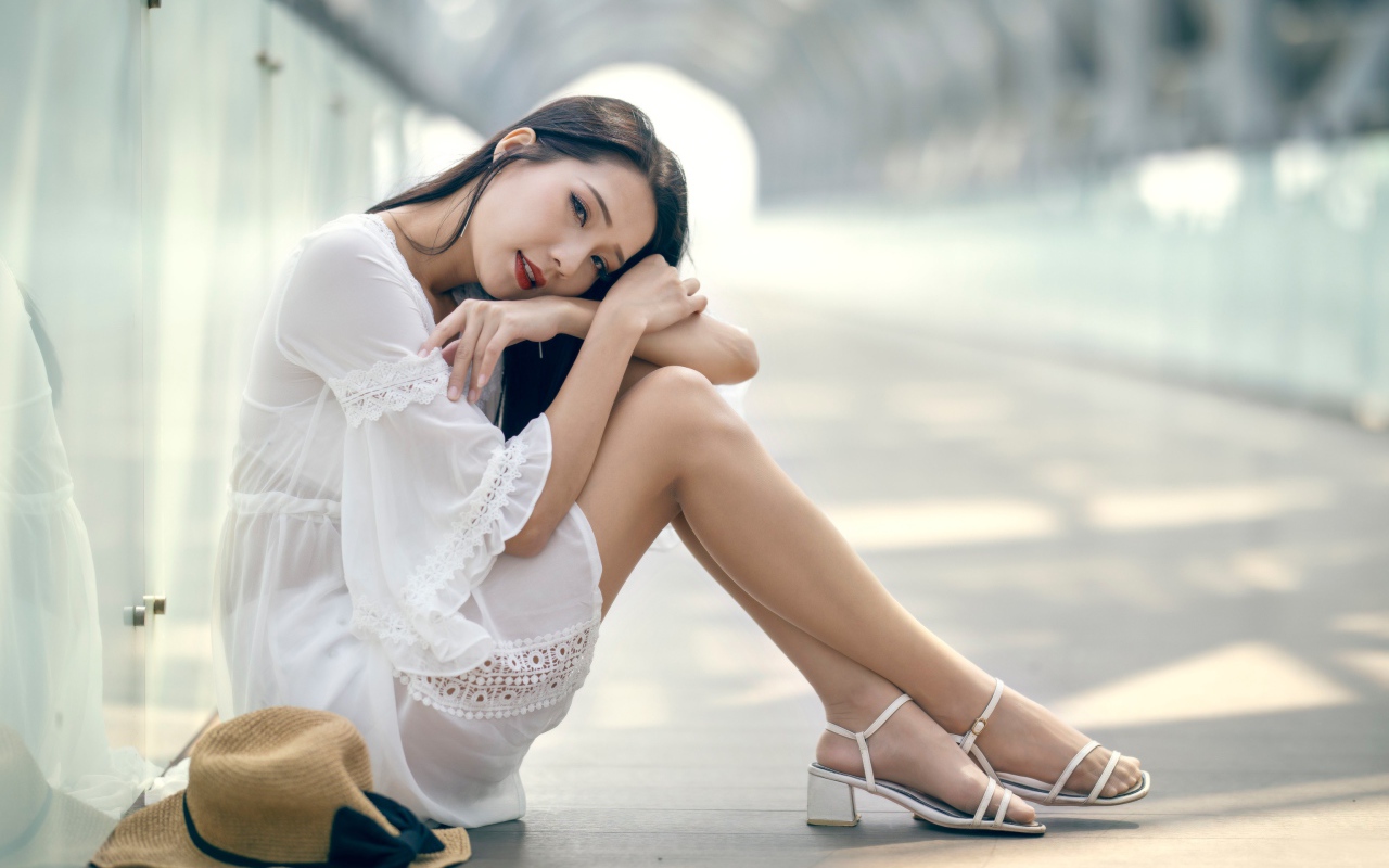 Красивая девушка азиатка в белом платье на полу 