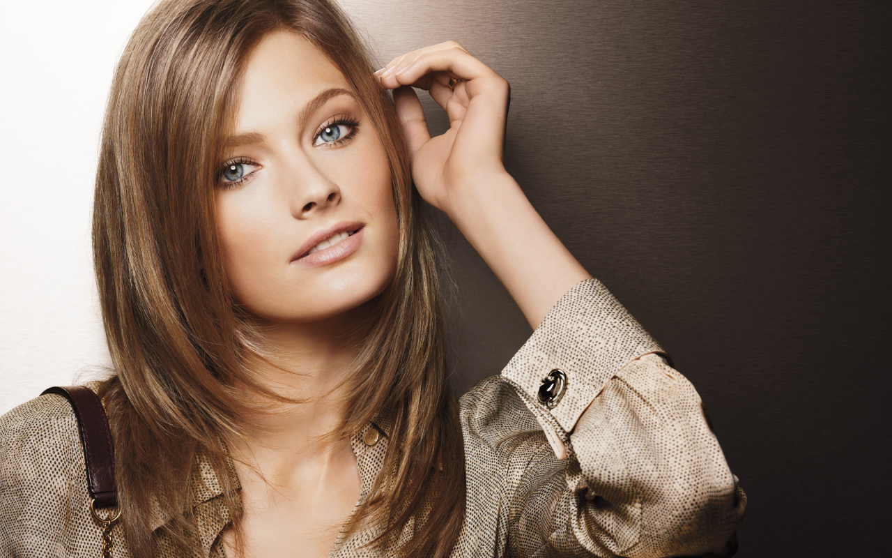 Красивая голубоглазая девушка в рубашке на коричневом фоне 