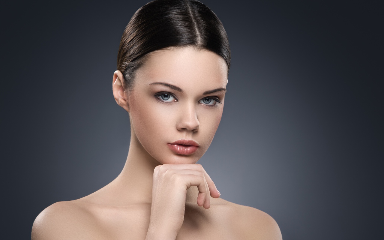 Красивая голубоглазая девушка на сером фоне 