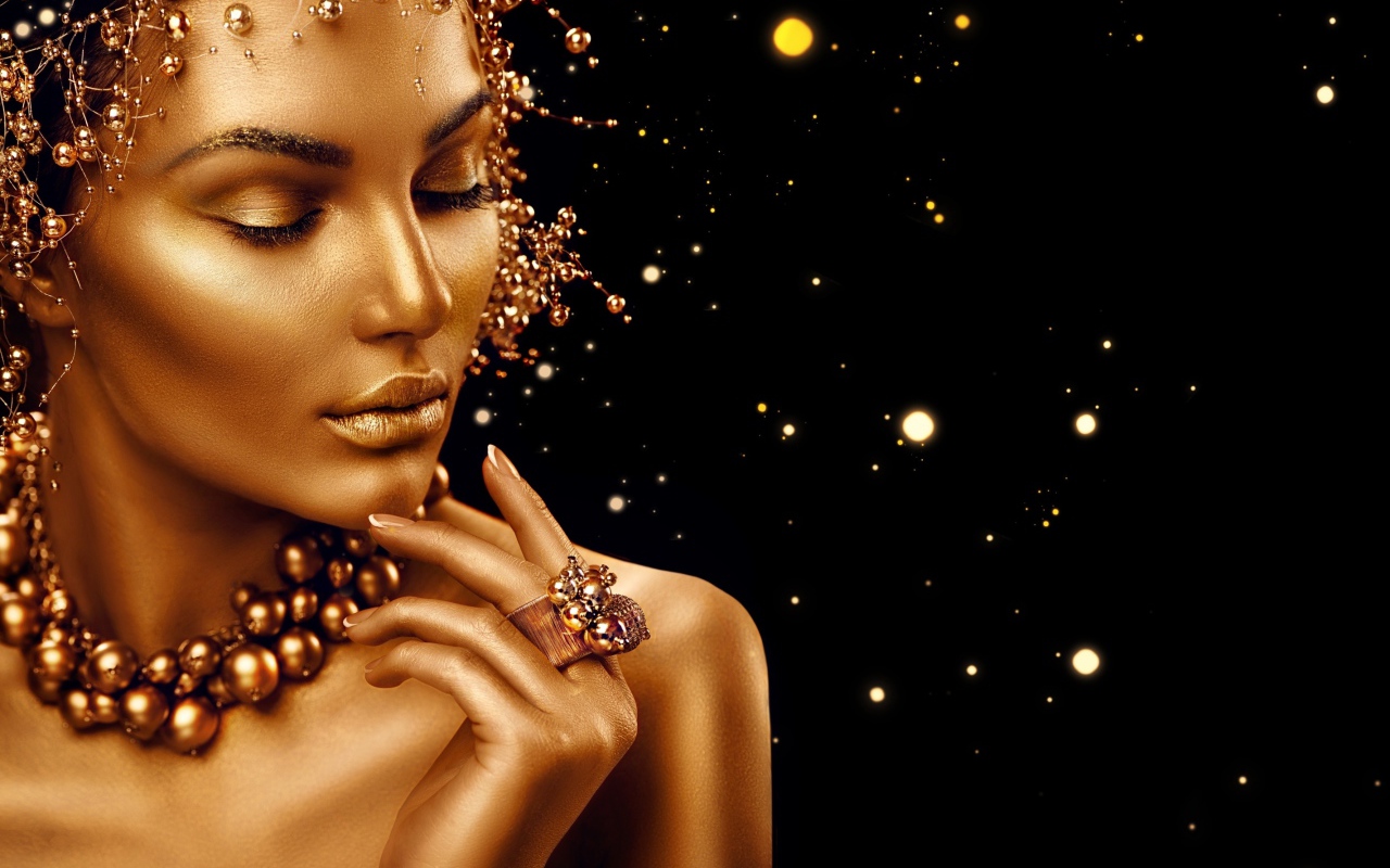 Красивая девушка в золотой краске на черном фоне