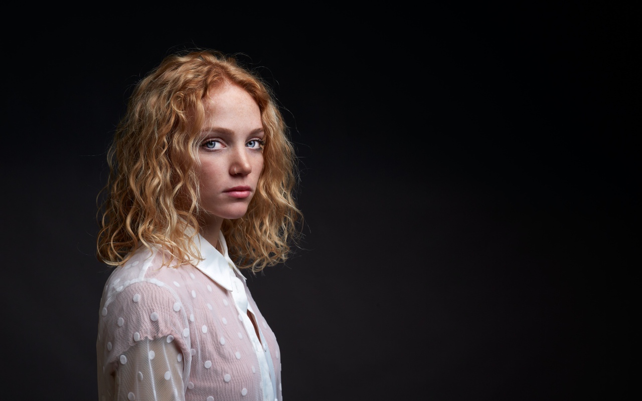 Голубоглазая девушка в белой рубашке на черном фоне