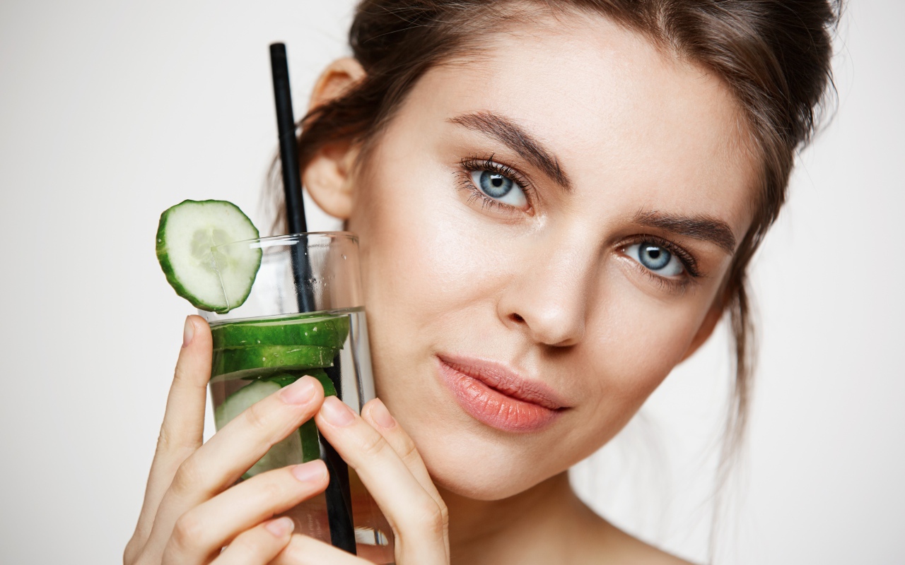 Голубоглазая девушка с огуречным напитком в руке 