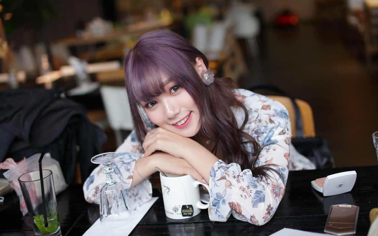 Милая девушка азиатка сидит за столиком