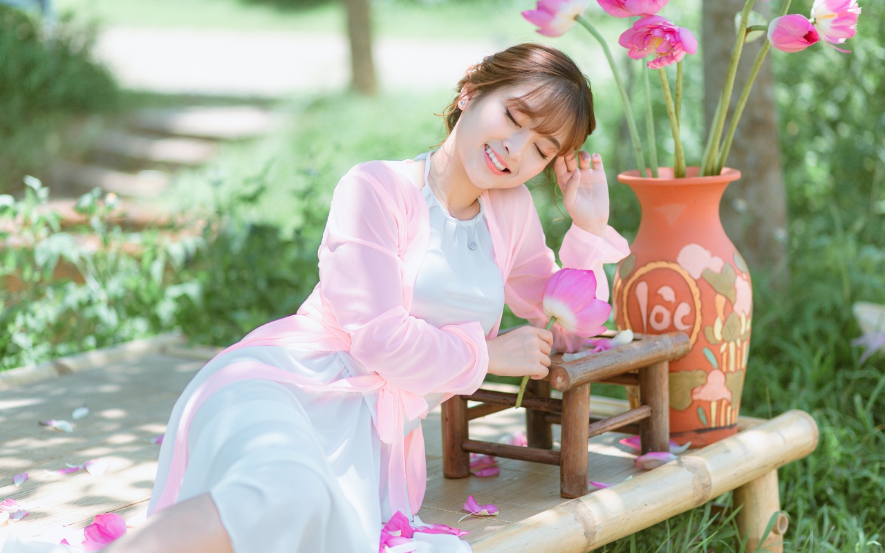 Мечтательная девушка азиатка с цветами лотоса