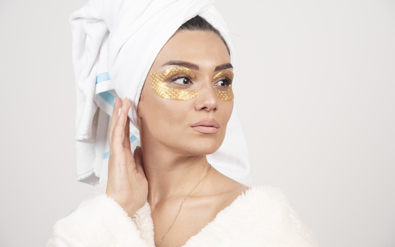 Девушка после душа с золотыми патчами под глазами