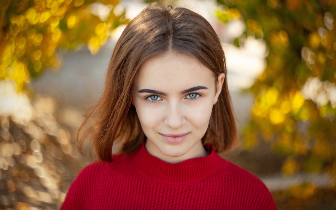 Девушка в красном свитере с короткой стрижкой 