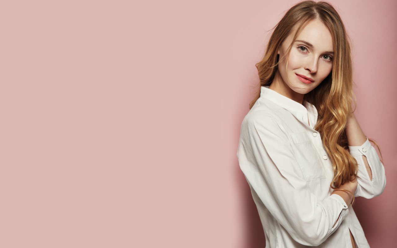 Девушка в белой рубашке на розовом фоне