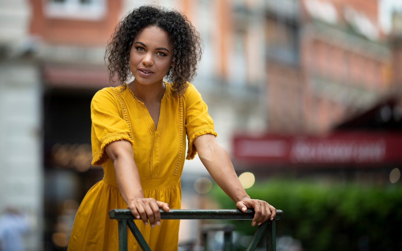 Девушка с кудрявым волосами в желтом платье