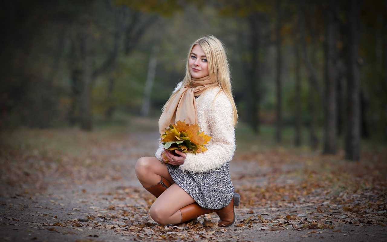 Девушка с листьями на дороге осенью
