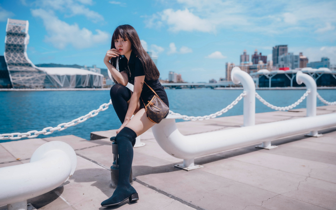 Молодая азиатка сидит в порту 