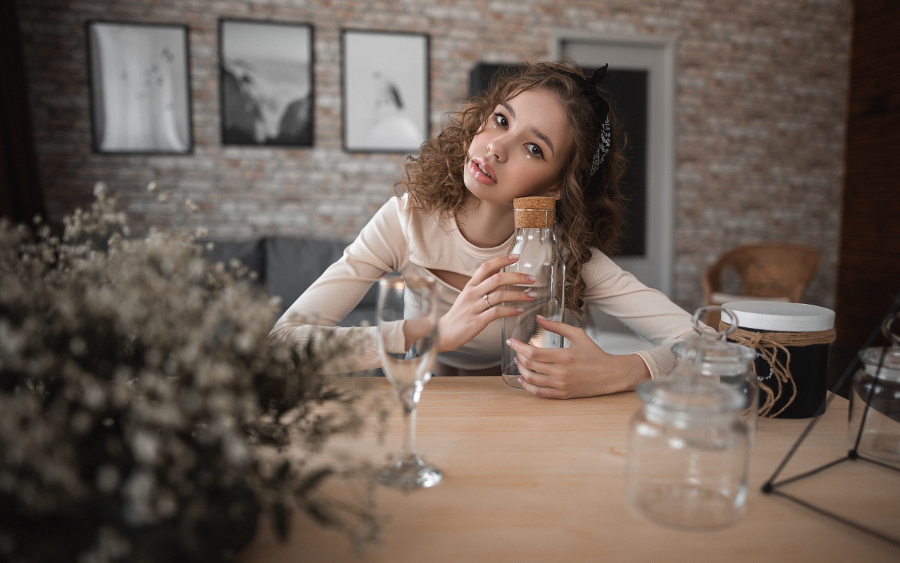 Молодая девушка модель сидит в кафе за столом