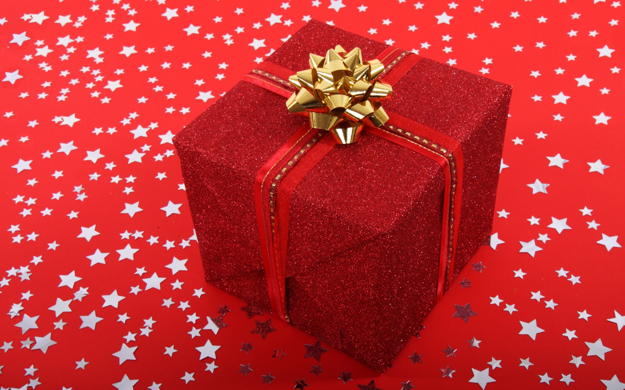 Big gift with a bow on a red background with stars