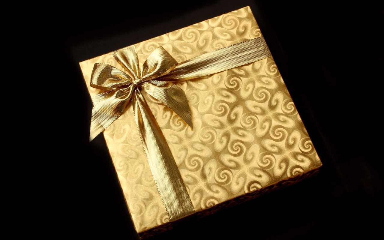 Золотая упаковка с подарком на черном фоне