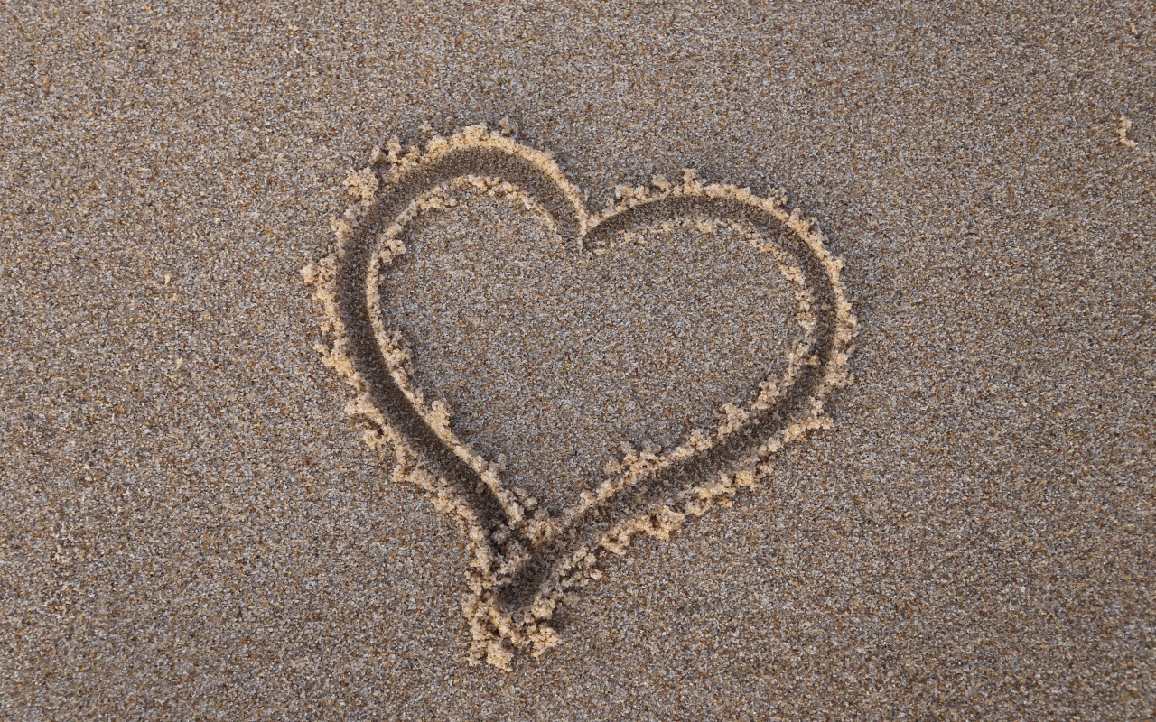 Сердце нарисовано на мокром песке 