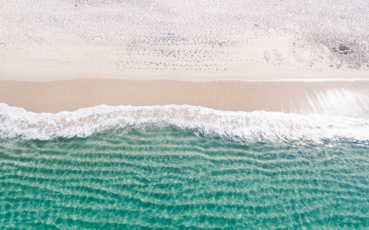 Белый морской песок на берегу у голубой воды