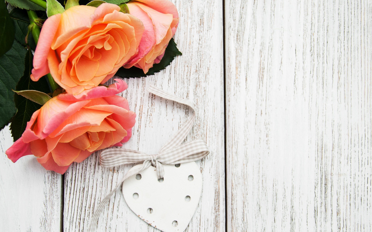 Три оранжевых цветка розы на сером столе