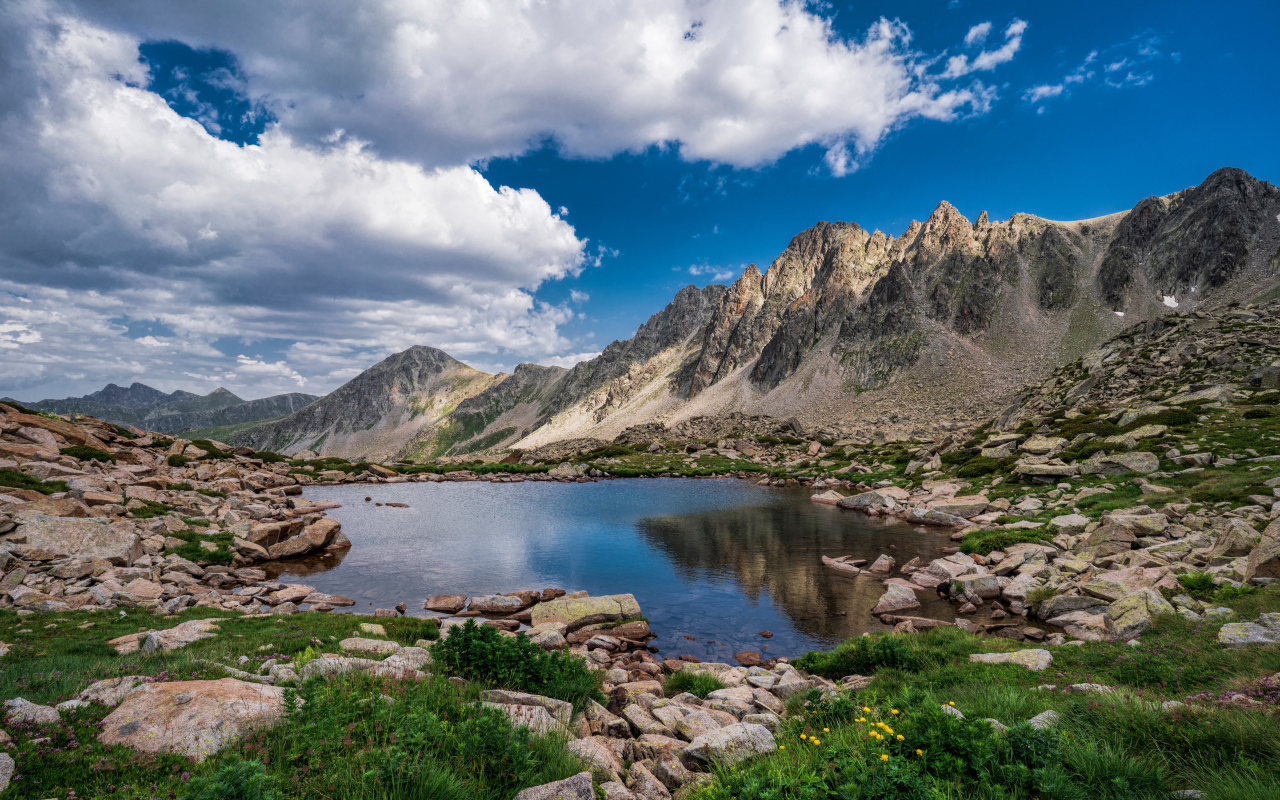 Горы под голубым небом с белыми облаками у озера, Андорра 