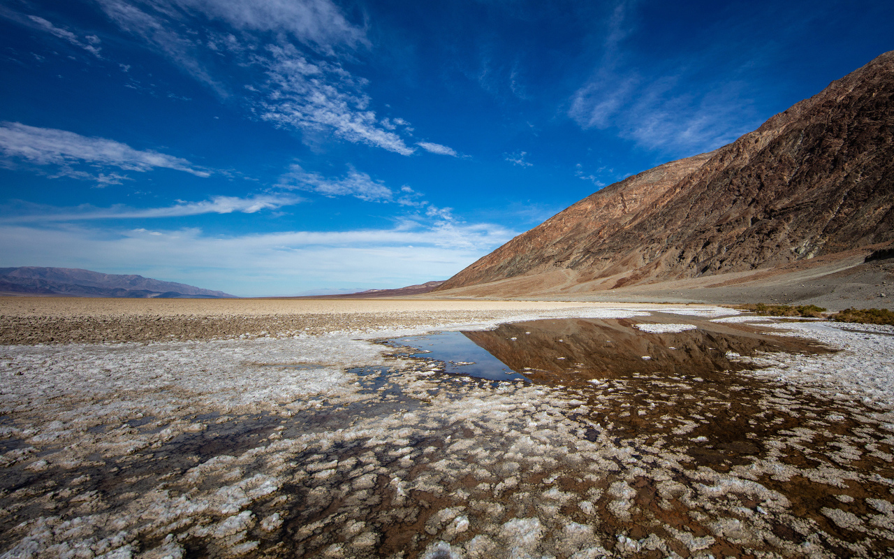 Соленая земля у горы под голубым небом