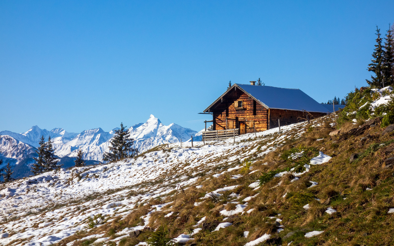Деревянный дом на заснеженном склоне Альп