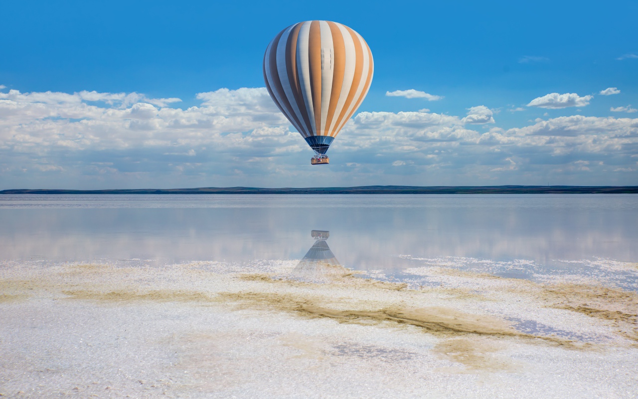 Большой воздушный шар летит на водой
