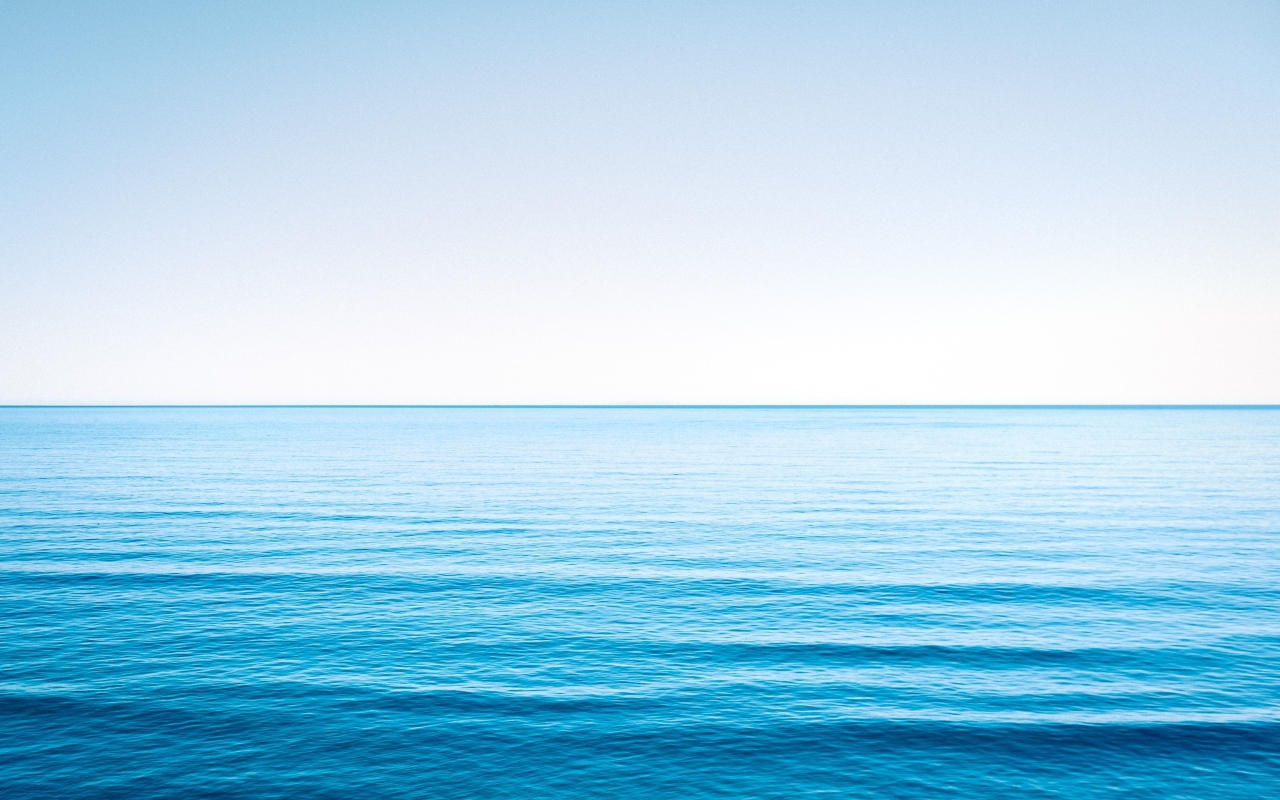 Спокойная голубая морская вода под голубым небом 