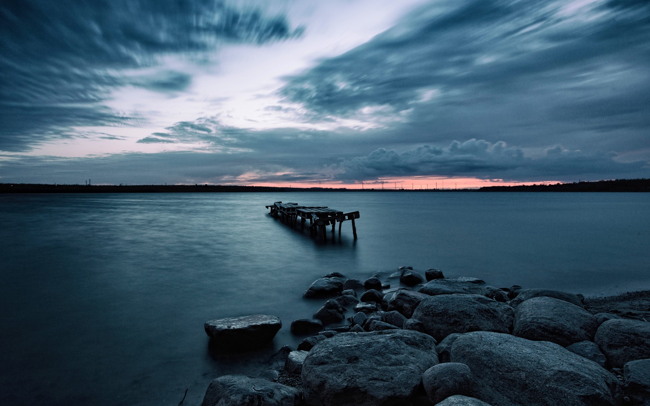 Большие камни на берегу у моря в сумерках 