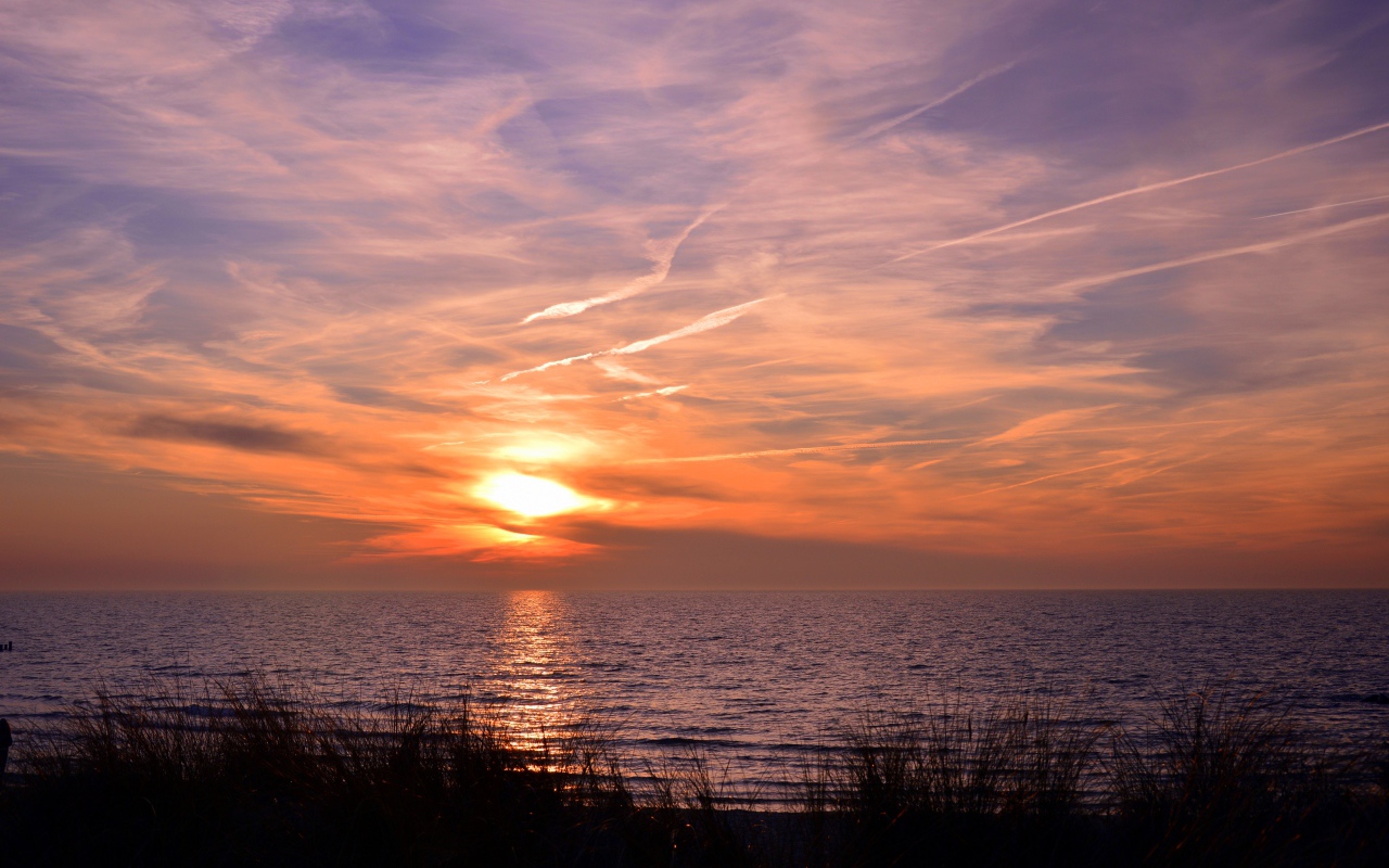 Закат солнца над спокойным озером летом