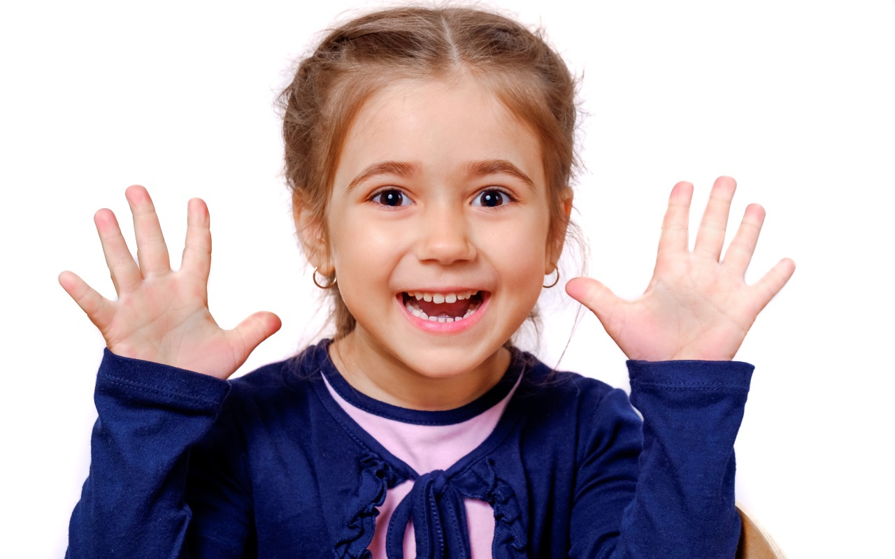 Веселая маленькая девочка с поднятыми руками