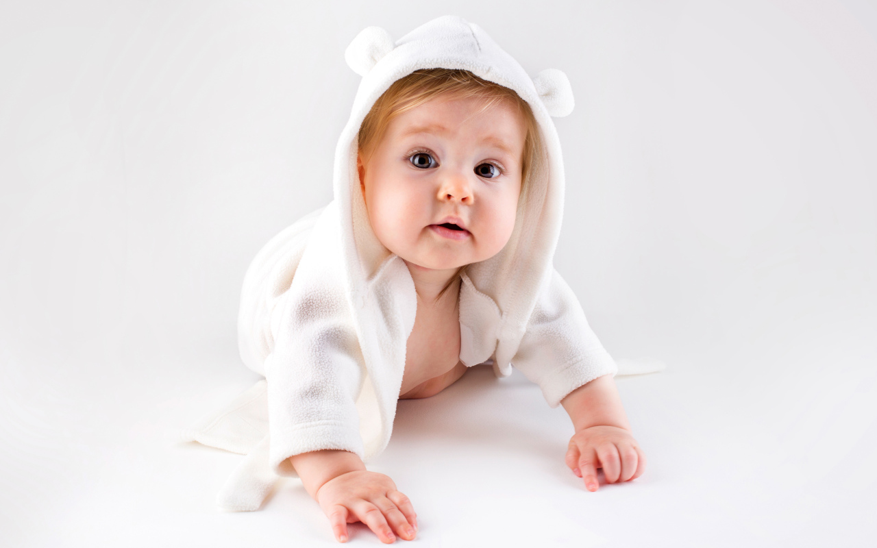 Забавный малыш ползает в белом наряде 