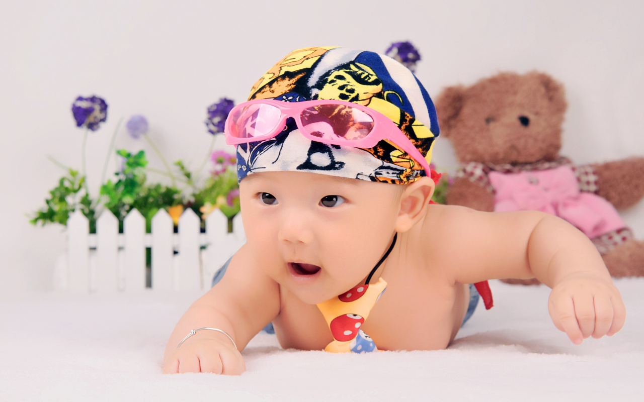 Маленький ребенок азиат в шапке с очками