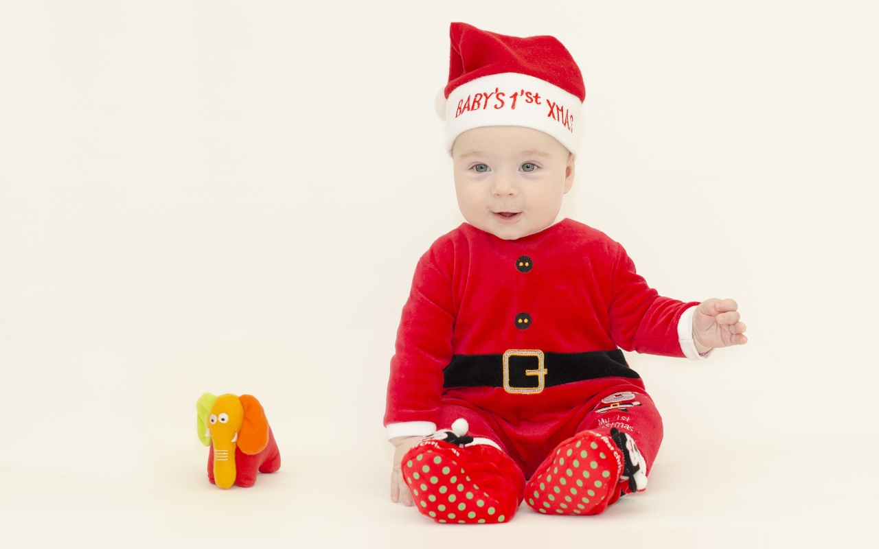 Маленький мальчик в новогоднем костюме на белом фоне
