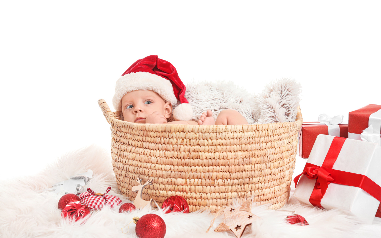 Маленький ребенок лежит в корзине с подарками на новый год