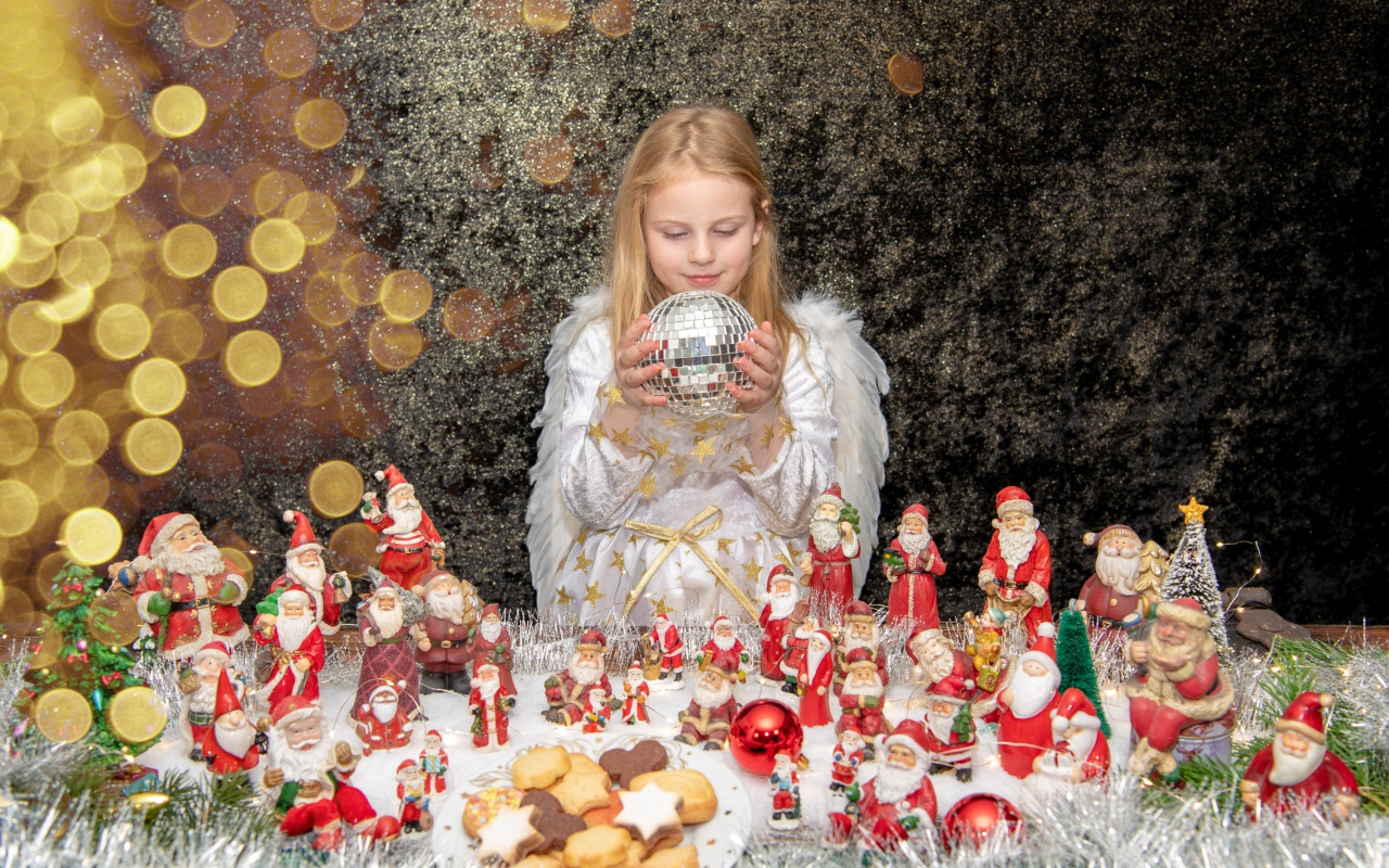 Маленькая девочка в костюме ангела с новогодним декором