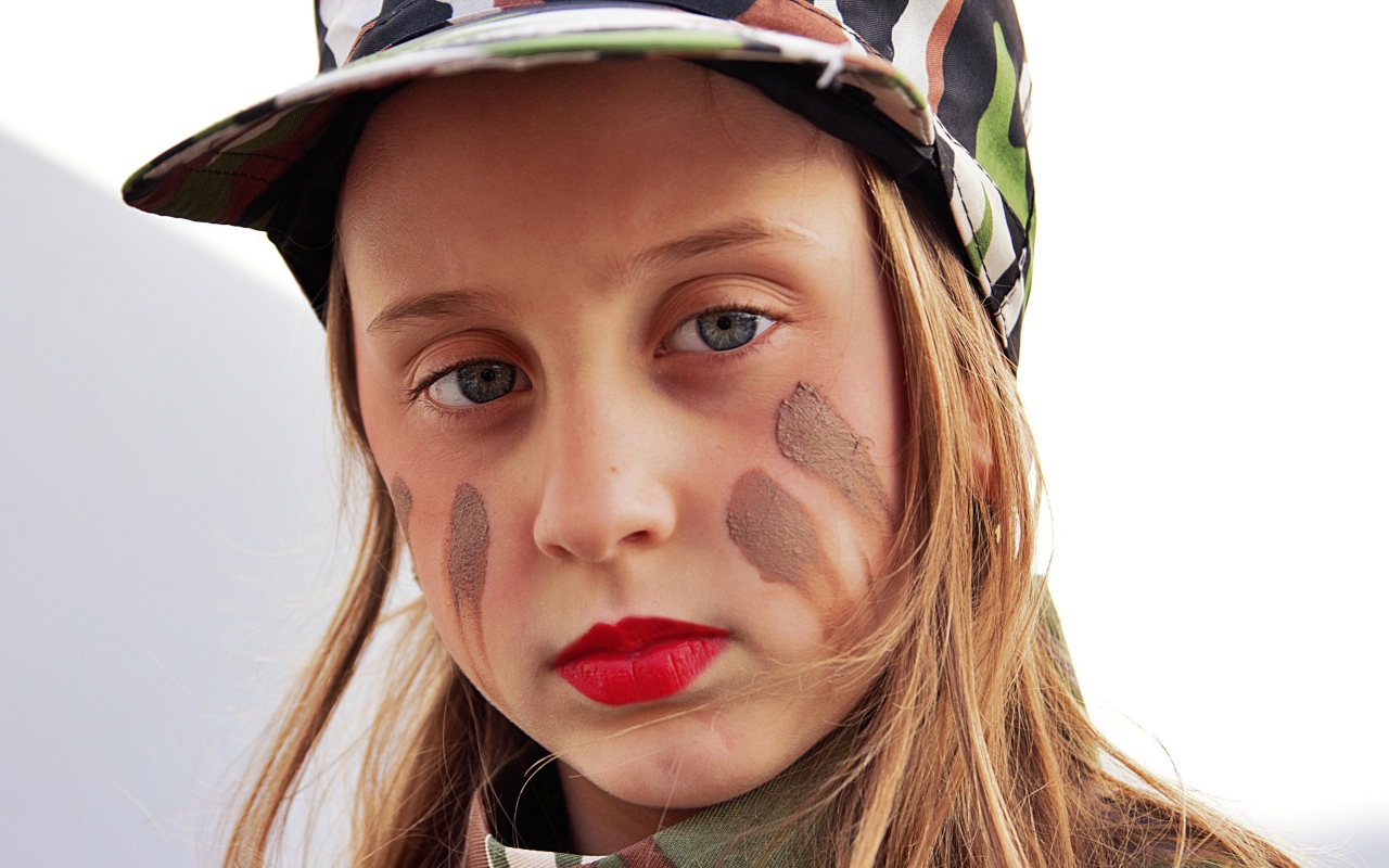 Маленькая девочка в кепке с грязью на лице