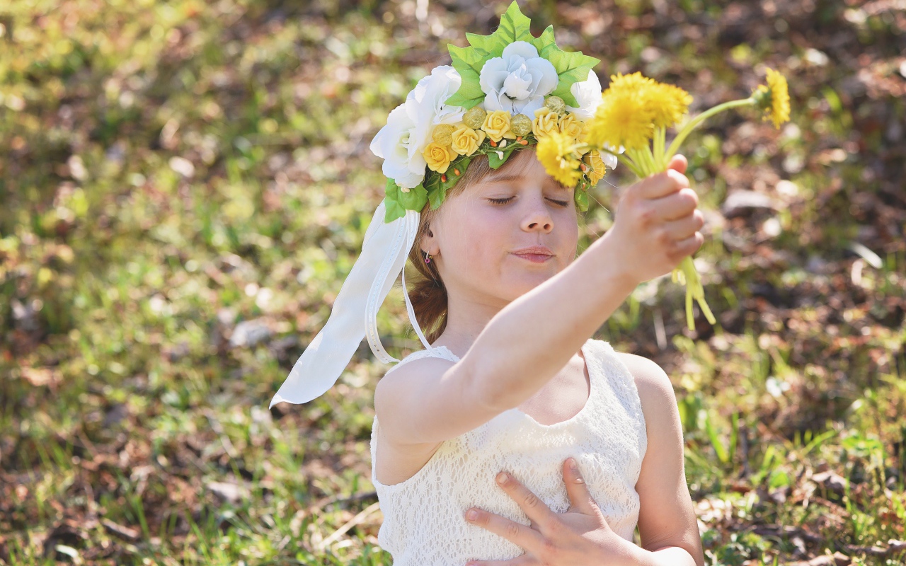 Маленькая девочка с букетом одуванчиках в руке 