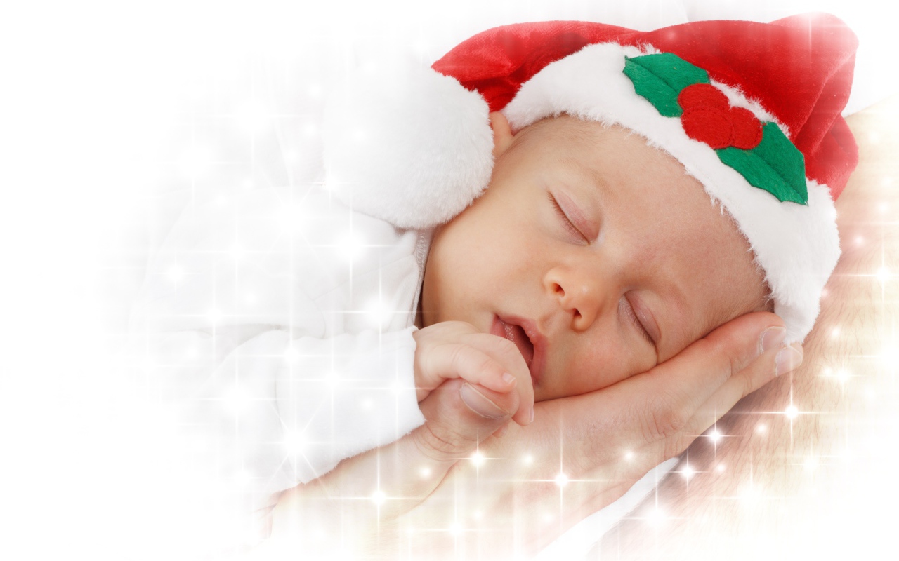 Маленький спящий ребенок в новогодней шапке 