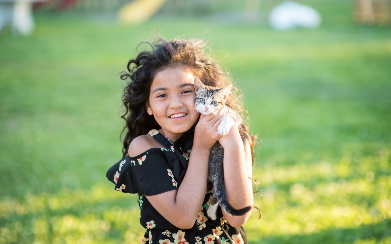Маленькая улыбающаяся девочка с котенком в руках