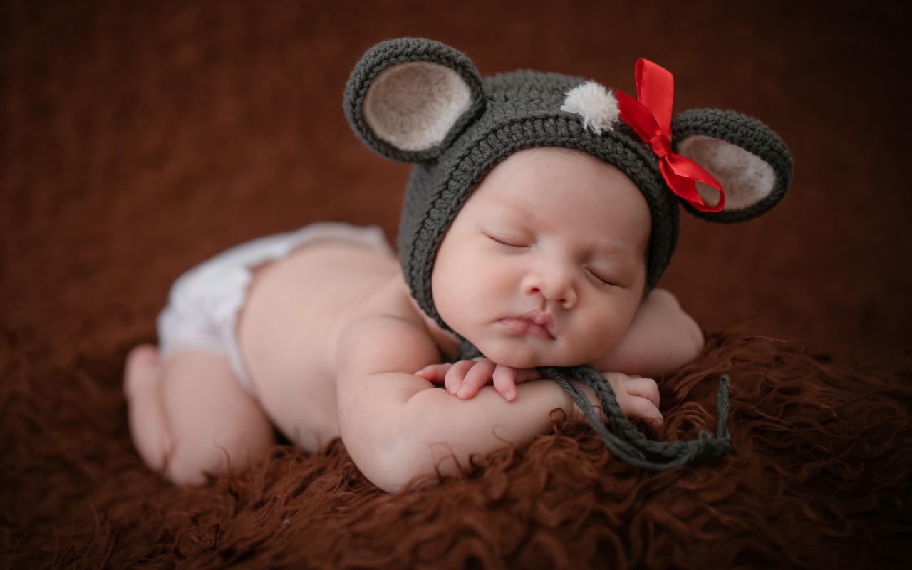 Новорожденный спящий ребенок в шапке мышонка 