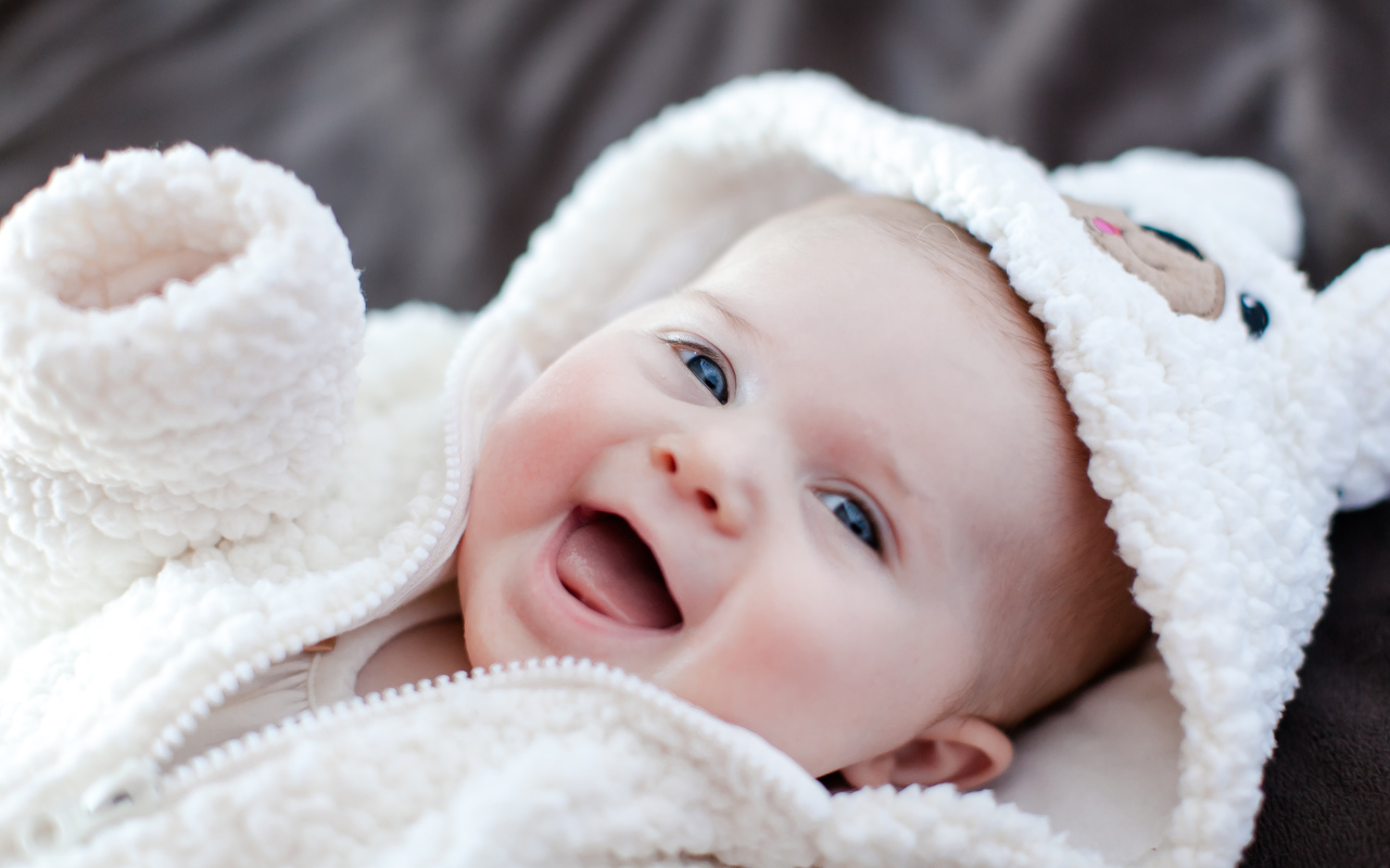 Улыбающийся милый ребенок в теплом костюме 