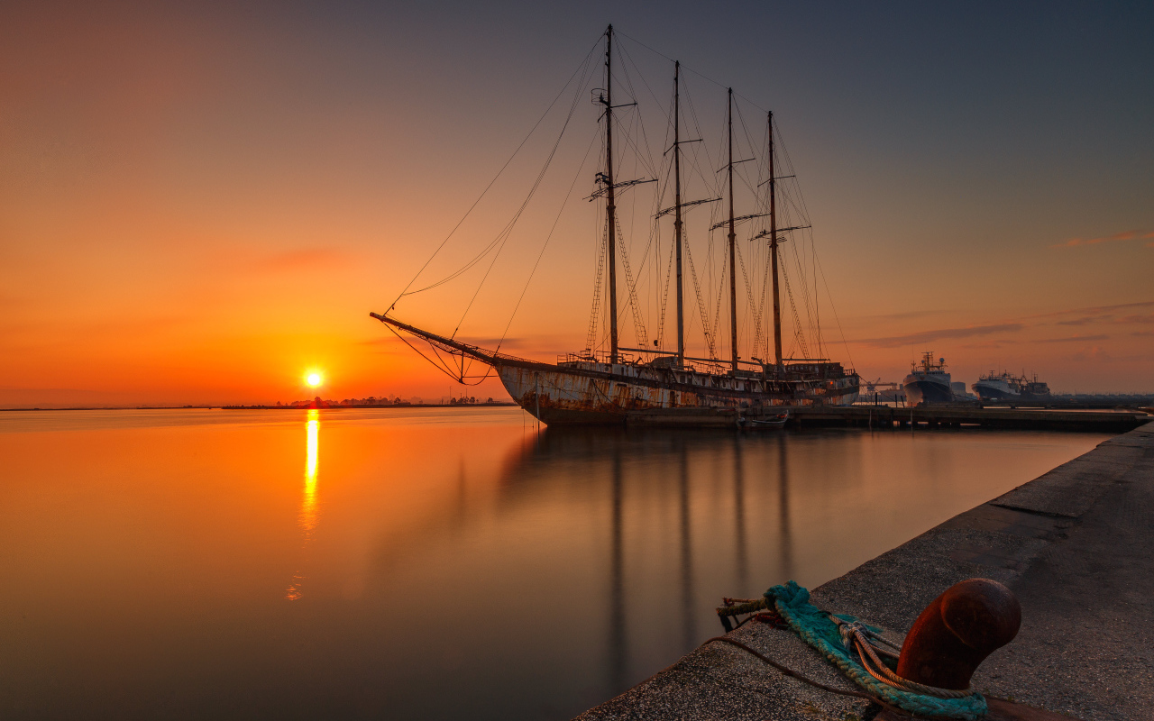 Большой корабль стоит на закате солнца 