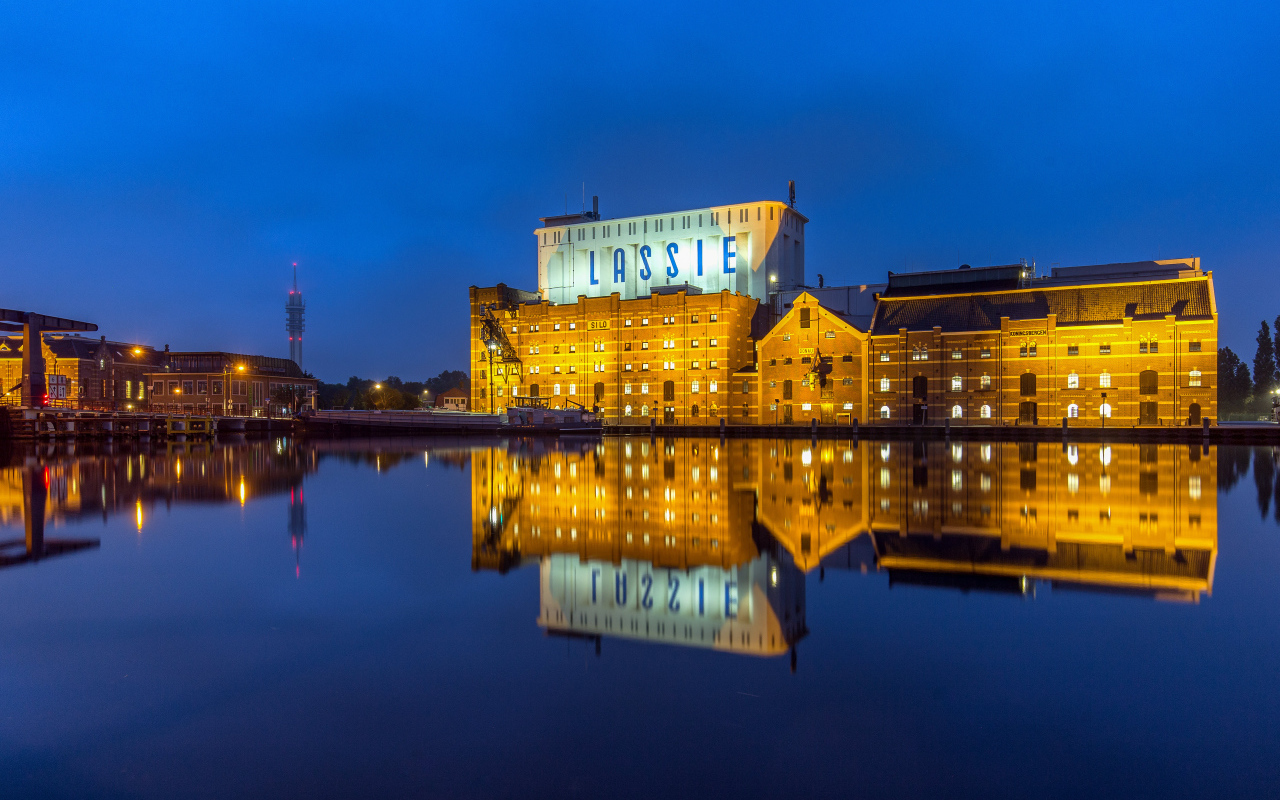Здание завода у воды ночью, Нидерланды