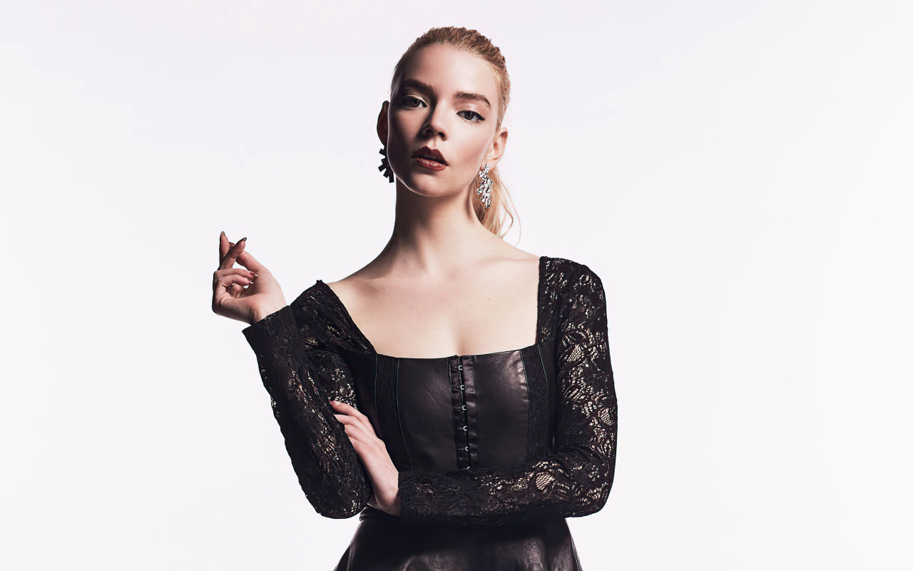 Актриса Аня Тейлор-Джой в черном наряде на белом фоне