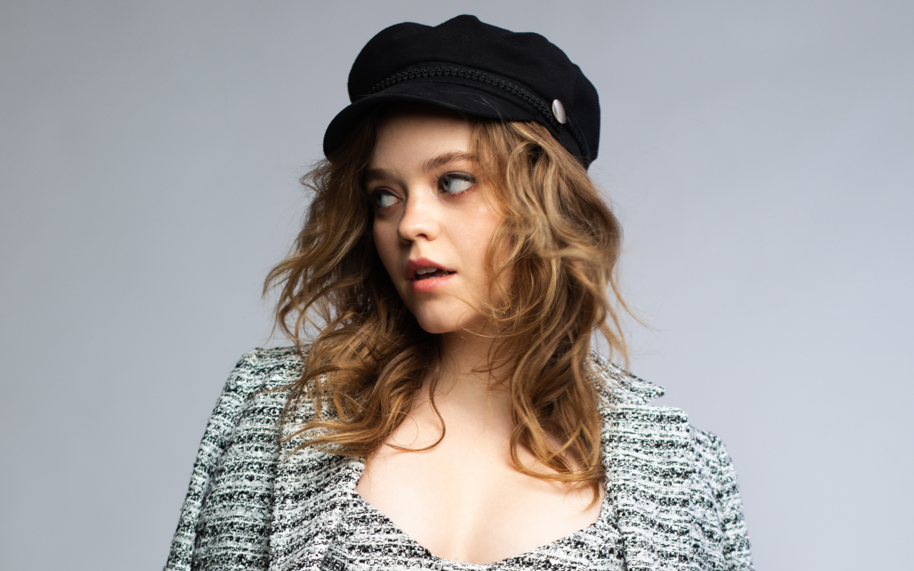 Актриса Джэйд Петтиджон смотрит в сторону на сером фоне